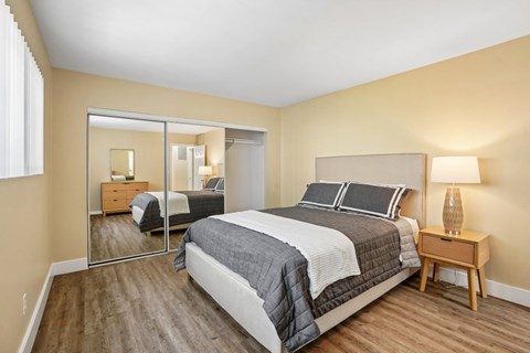 A bedroom with a large bed and a wooden nightstand.