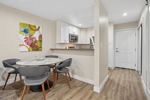 A kitchen with a dining table and chairs.