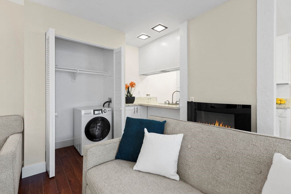 Living Room with Fireplace, Washer/Dryer, and Grey Couch at Casa De Marina Apartments, Los Angeles, California