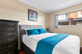 Apartments for Rent in Valley Village CA - Riverside Villa - Bedroom with Blue Pillows and Beige Walls - Photo Gallery 4