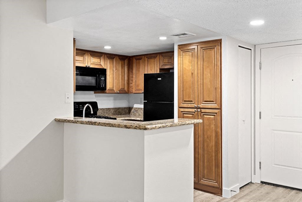 a kitchen with a counter top and a refrigerator at Woodland Trio Apartments, North Hollywood, CA