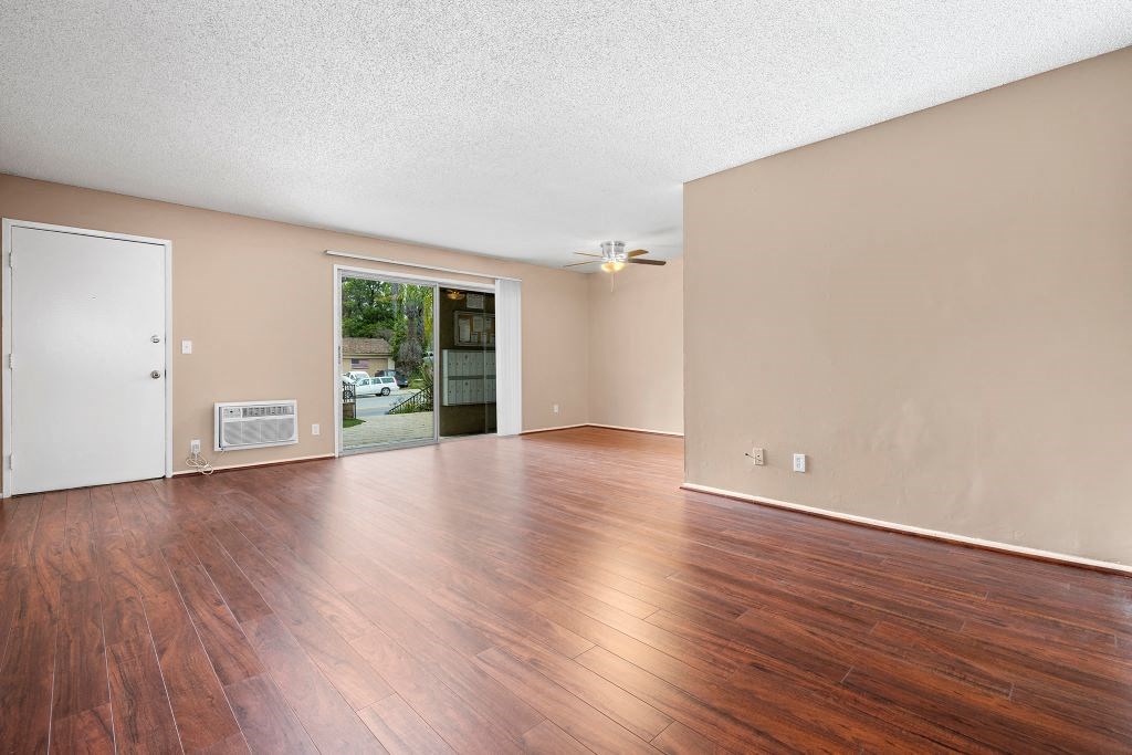 a living room with hardwood floors and a sliding glass door to a patio