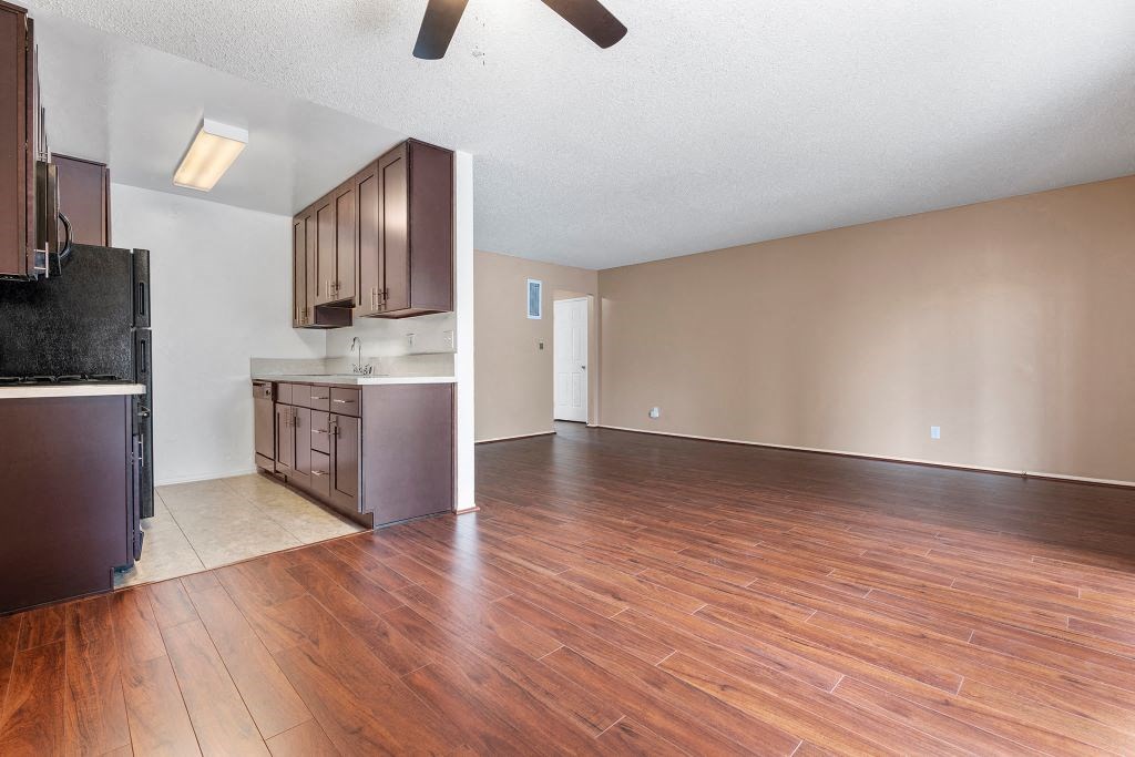a kitchen and living room with a ceiling fan