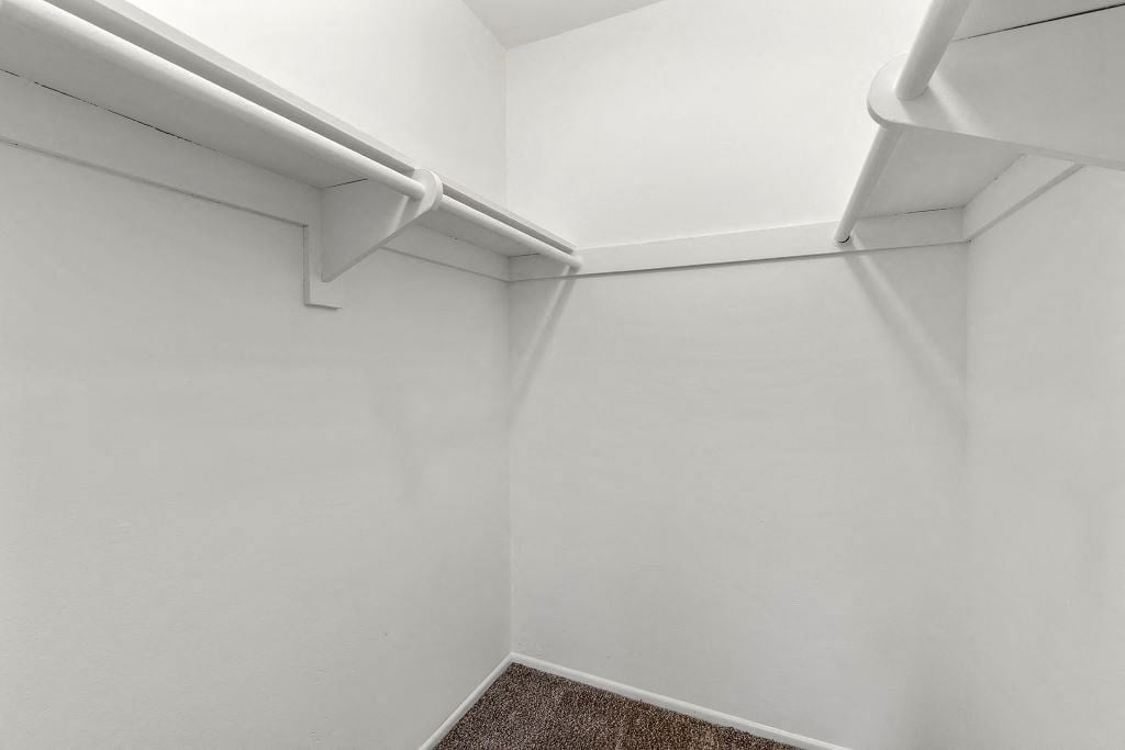 a small room with white walls and white shelves