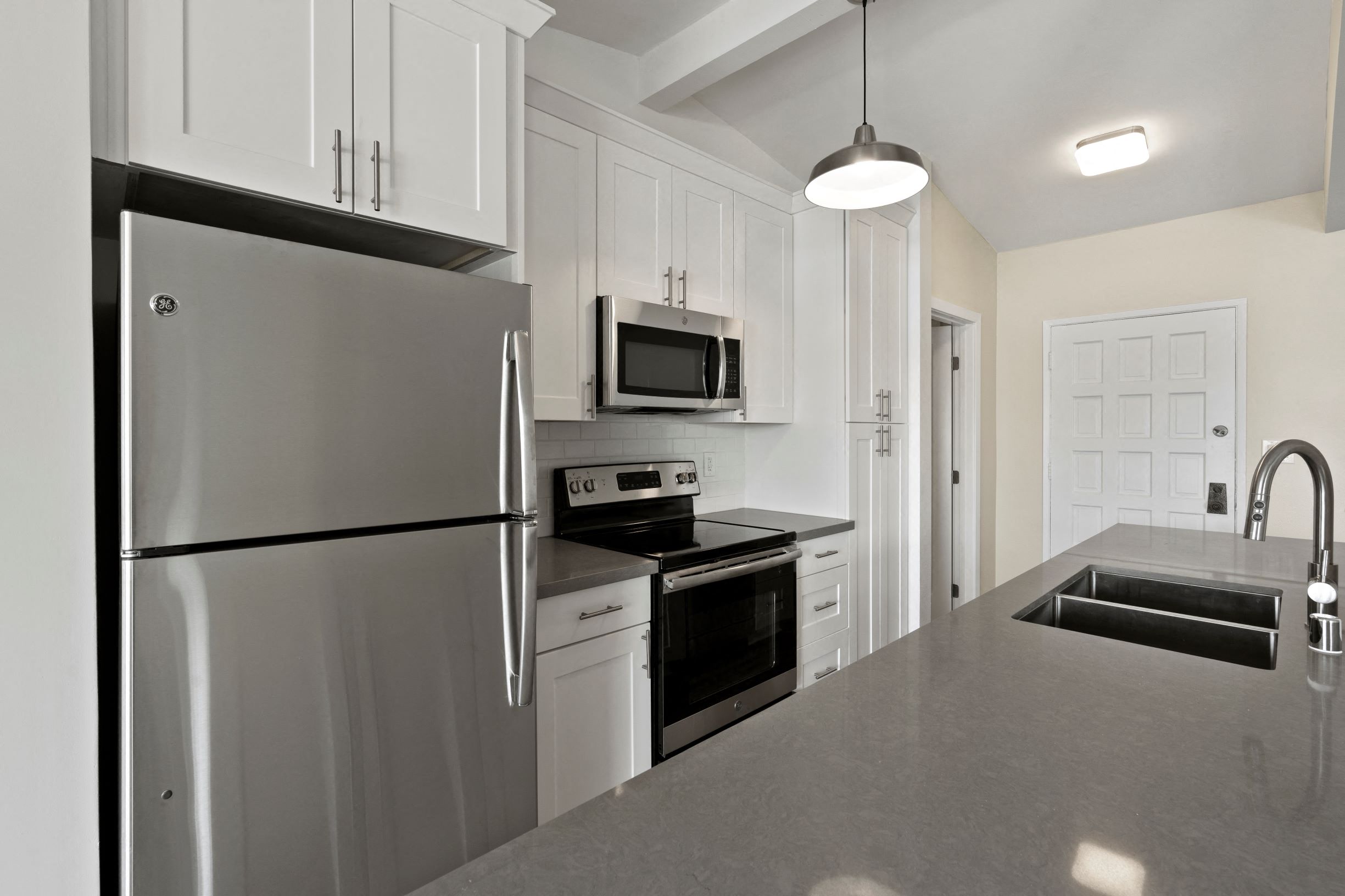 Culver City Apartments - Kitchen With Stainless Steel Appliances, Upgraded Cabinets, Granite Countertops, Dual Sink, And A Built-In Microwave.