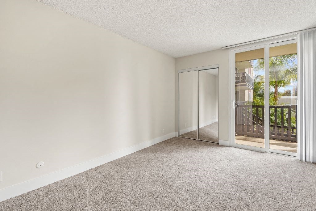 One Bedroom Apartments in Culver City CA - Parkway Plaza - Bedroom with Plush Carpeting, a Ceiling Fan, and a Closet with Mirrored Doors