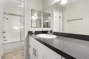 A bathroom with a sink, mirror, and a shower. at Parkway Plaza Apartments, Culver City, CA, 90230