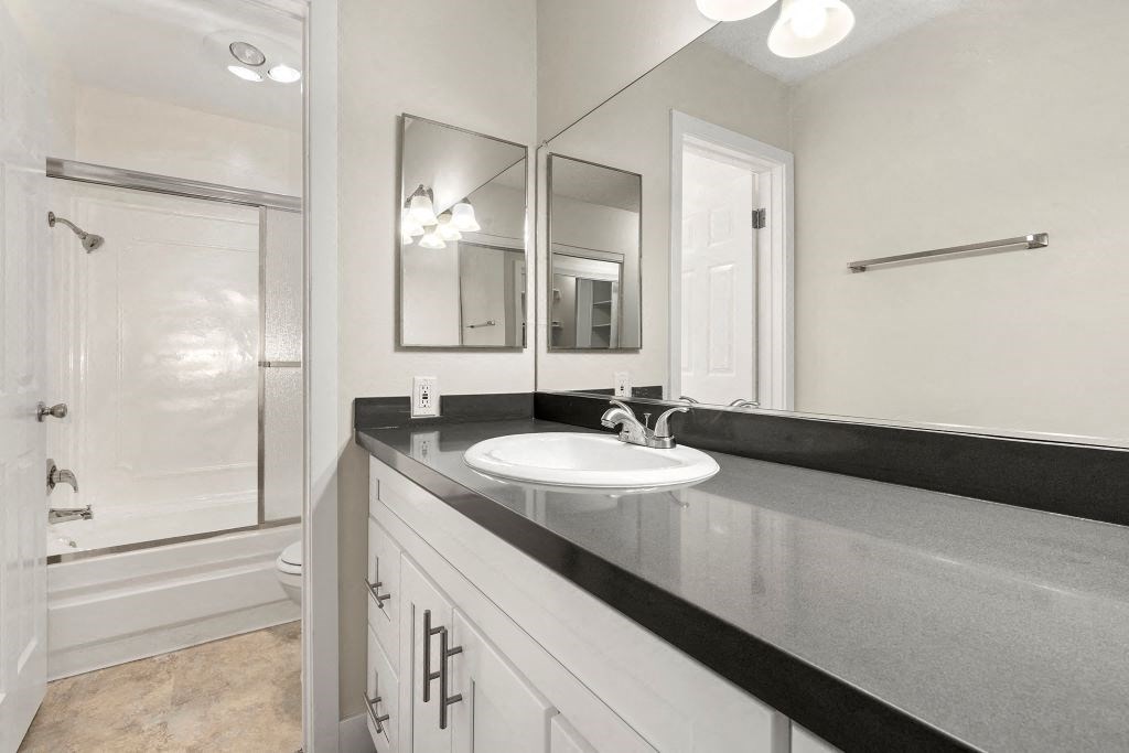 Apartments For Rent In Culver City, CA - Parkway Plaza - Bathroom With Dark Counter Tops And White Cabinetry With Toliet And Shower Separate From Sink And Vanity
