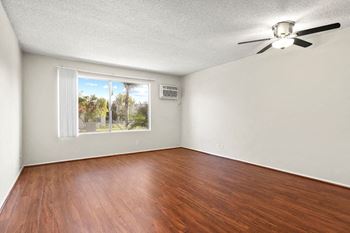 an empty living room with a window and a ceiling fan at Riverside Villas Apartments, California, 91602