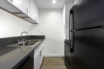 an empty kitchen with a sink and a refrigerator at Topanga Canyon Apartments, West Hills, 91304