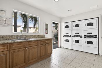 a white laundry room with a sink and washer and dryer