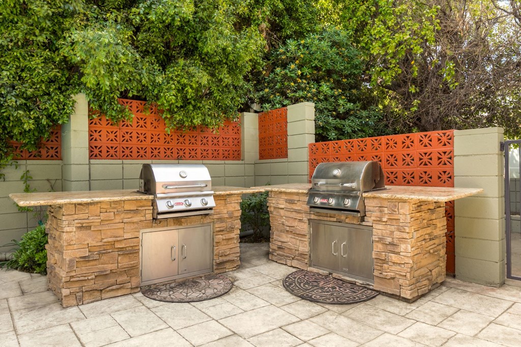 Apartments For Rent In Encino CA - White Oak Terrace - Exterior View Of Community Barbecue Grills Featuring Two Stainless Steel Built-In Grills on Rough Stone Outdoor Kitchen Counters