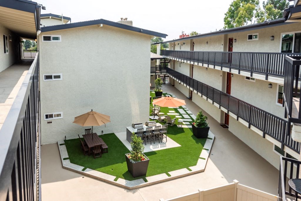 Apartments For Rent In Culver City -Picnic Area With Gas BBQ Grills, Chairs, Tables, Potted Plants, Well-Cut Grass, And In The Center Of The Complex.