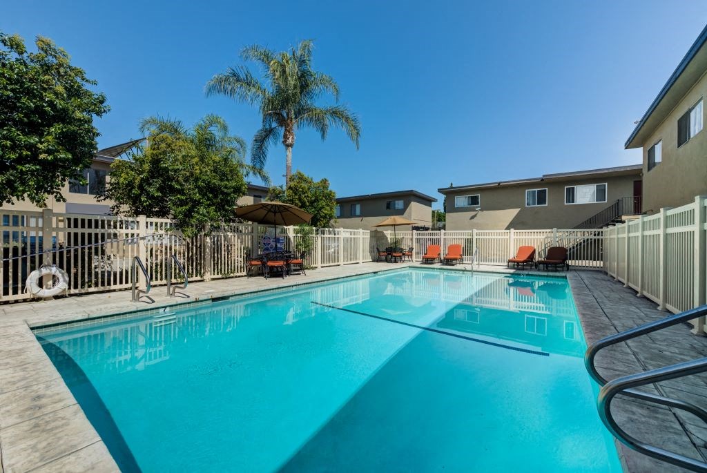 Large Swimming Pool Surrounded by Lounge Chairs and Tables at Parthenia Terrace Apartments, Canoga Park