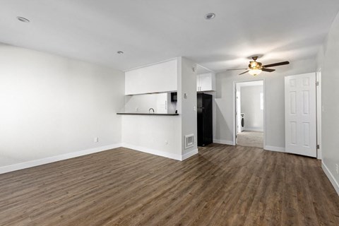Apartments for Rent in West Hills, CA - Topanga Canyon - Interior View of Living Room Adjacent to Kitchen with Hardwood Flooring and a Ceiling Fan