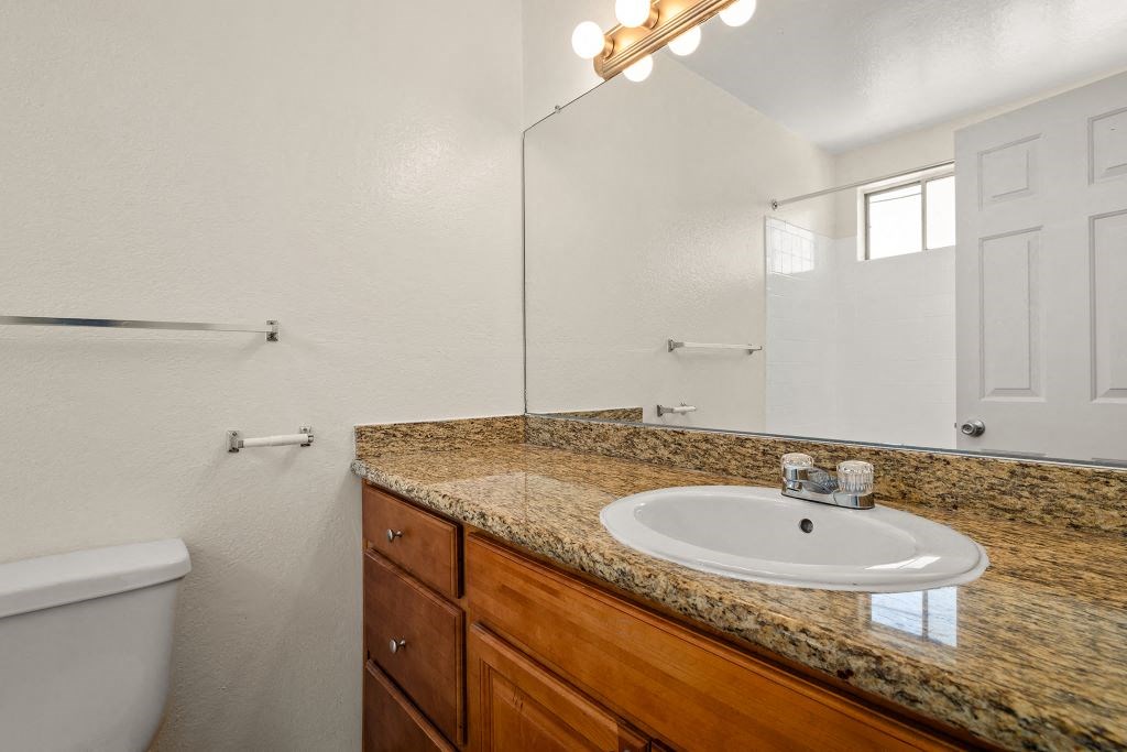 a bathroom with a sink and a toilet and a mirror at Topanga Canyon Apartments, West Hills, CA, 91304
