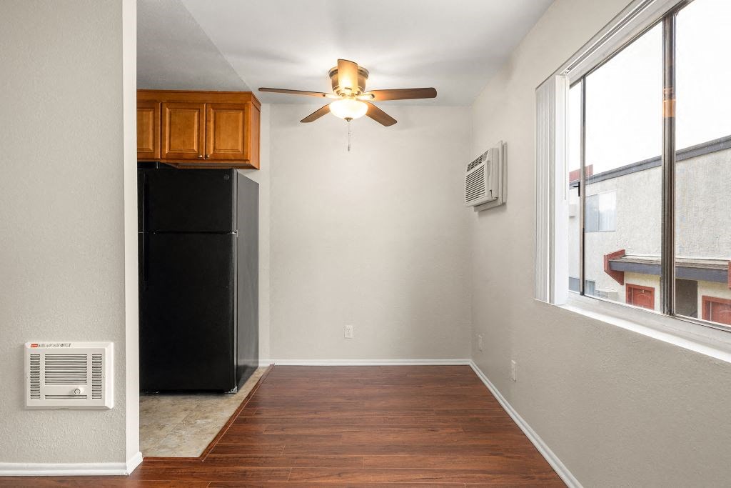 an empty room with a ceiling fan and a refrigerator at Topanga Canyon Apartments, California