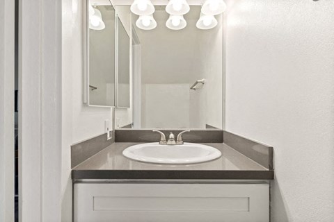 a bathroom with a sink and a mirror at Parkway Plaza Apartments, Culver City, 90230