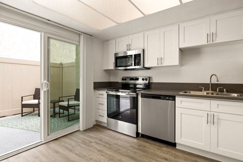 a kitchen with stainless steel appliances and a sliding glass door at Parkway Plaza Apartments, Culver City, CA