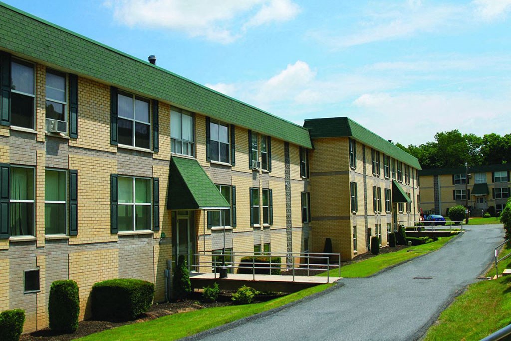 a row of brick apartment buildings with green roofs