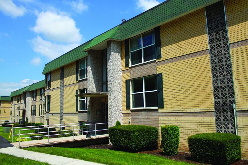 a building with a green roof and a sidewalk in front of it