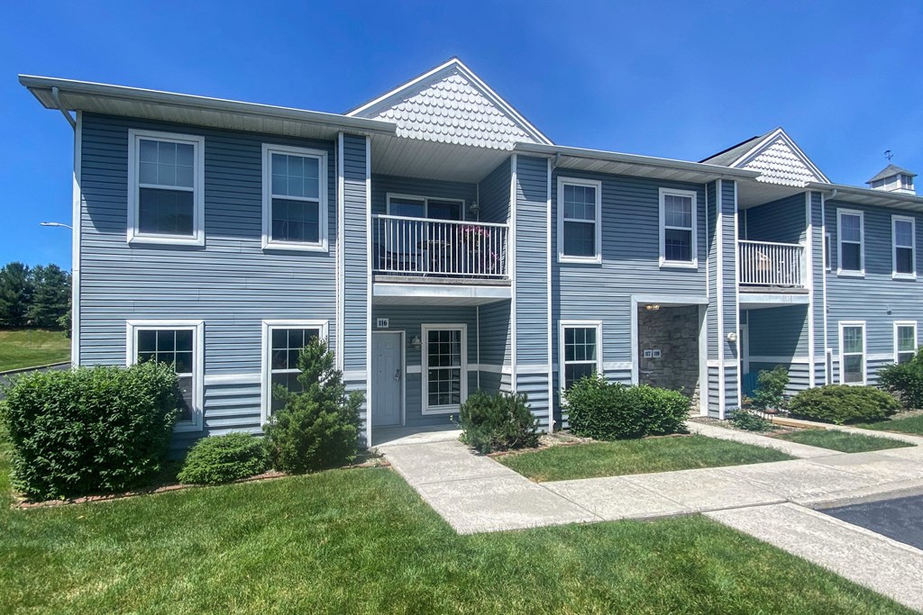 A two-story house with a balcony on the second floor.