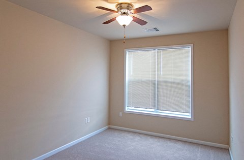 a bedroom with a ceiling fan and a large window