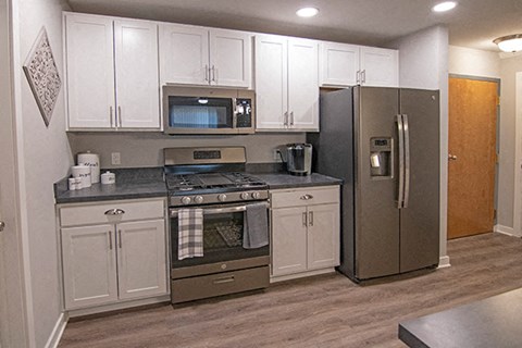 a kitchen with stainless steel appliances and white cabinets