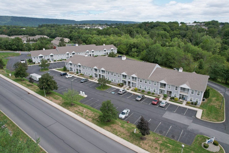 A large white building with a parking lot in front of it.
