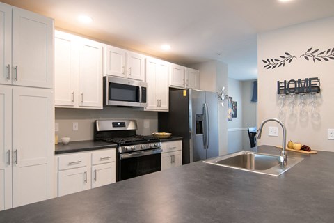a kitchen with stainless steel counter tops and white cabinets