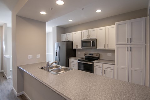 A kitchen with a sink, stove, and refrigerator.