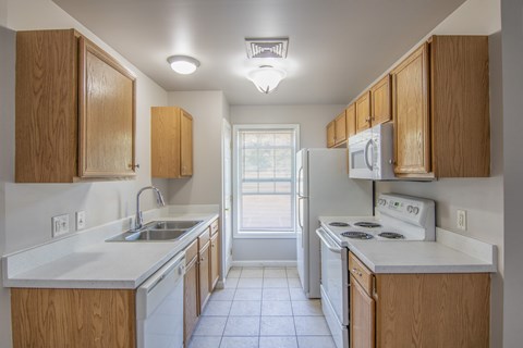 A kitchen with wooden cabinets and white appliances.