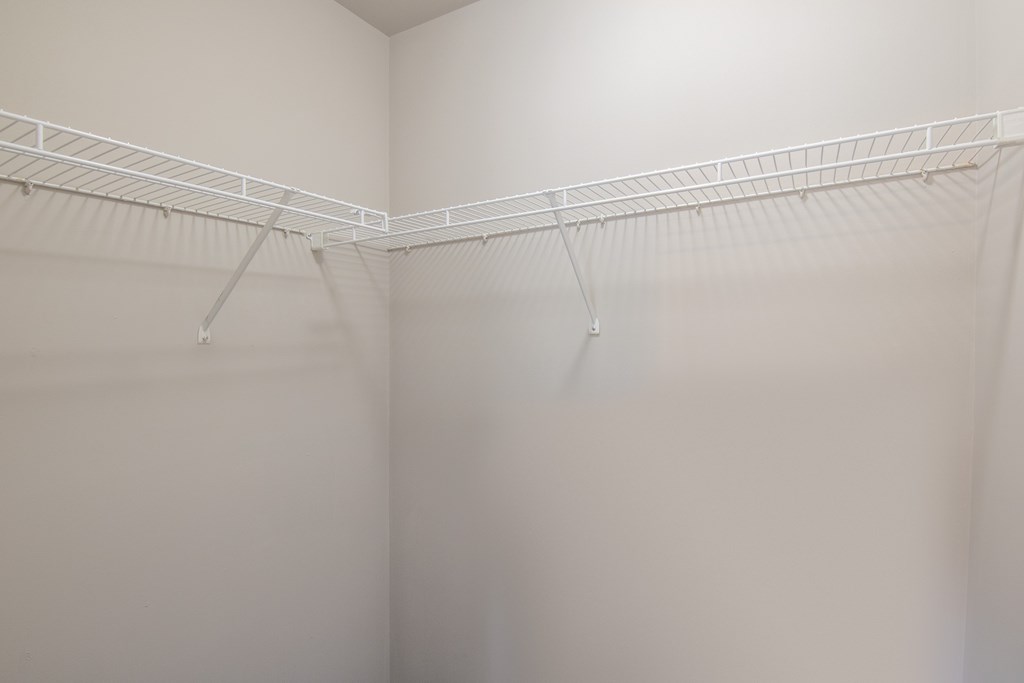 A white closet with a metal rod.