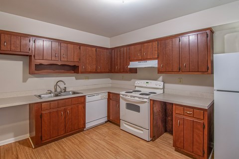 A kitchen with wooden cabinets and white appliances.