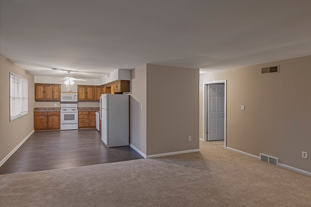 A kitchen with a refrigerator, oven, and cabinets.