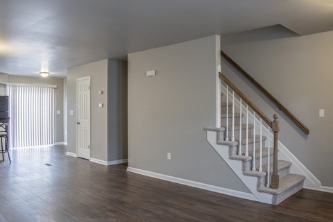 an empty living room with a staircase in a house