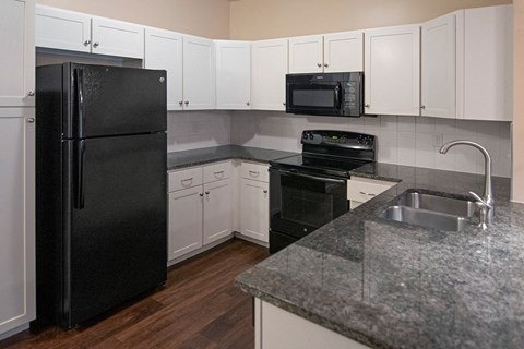 a kitchen with black appliances and white cabinets