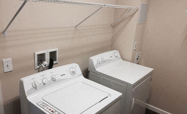 two white washing machines in a room with a sink