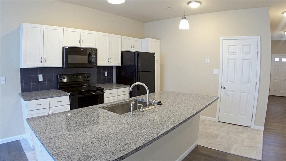 a kitchen with a granite counter top and black appliances