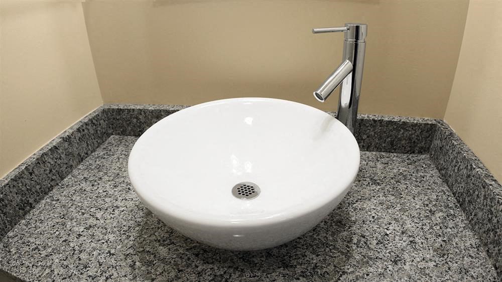 a white sink in a bathroom with a faucet