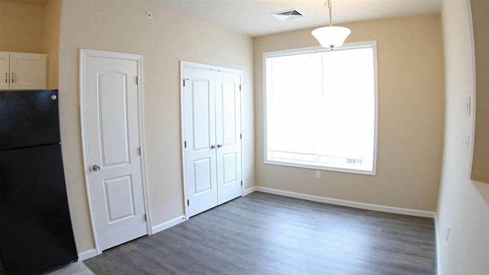 an empty living room with two doors and a window