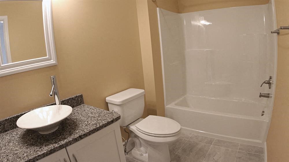 a bathroom with a toilet and a sink and a shower