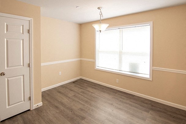 an empty room with a window and a white door