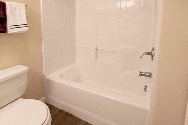 a bathroom with a white tub and a toilet