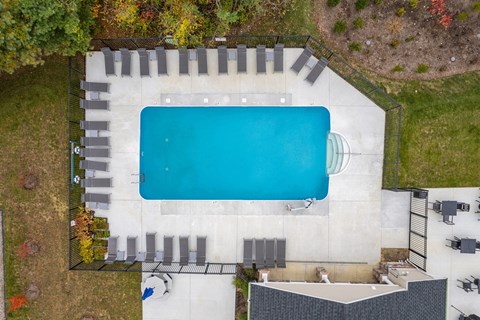 An aerial view of a swimming pool surrounded by a concrete wall and steps.