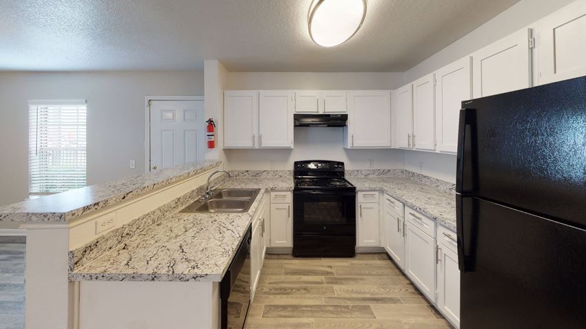 a kitchen with white cabinets and black appliances - Photo Gallery
