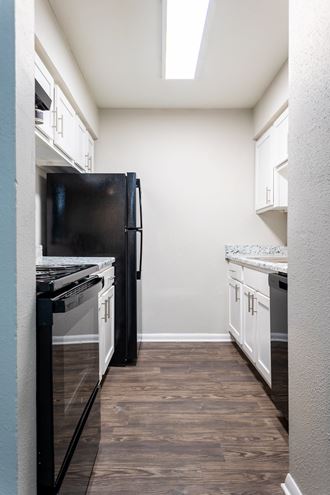 a kitchen with white cabinets and black appliances