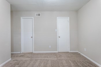 a bedroom with a carpeted floor and two doors - Photo Gallery 14