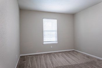 a bedroom with a window and a carpeted floor - Photo Gallery 13