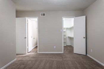 a bedroom with a carpeted floor and a closet with two doors - Photo Gallery 15